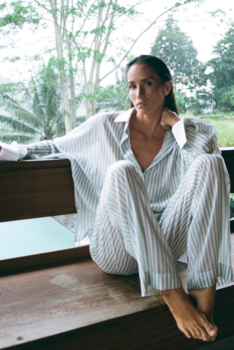 Light, effortless, and made for slow mornings by the sea. This relaxed striped cotton set brings the feeling of vacation the moment you put it on — soft on the skin, breathable in warm weather, and elegant without trying too hard.
The oversized shirt with crisp white cuffs and flowing wide-leg trousers create that perfect balance of comfort and refined resort style. Ideal for breakfasts on the terrace, barefoot evenings in Bali, yacht days in Dubai, weekends in Sardinia, or sunset walks in Greece.
It’s not